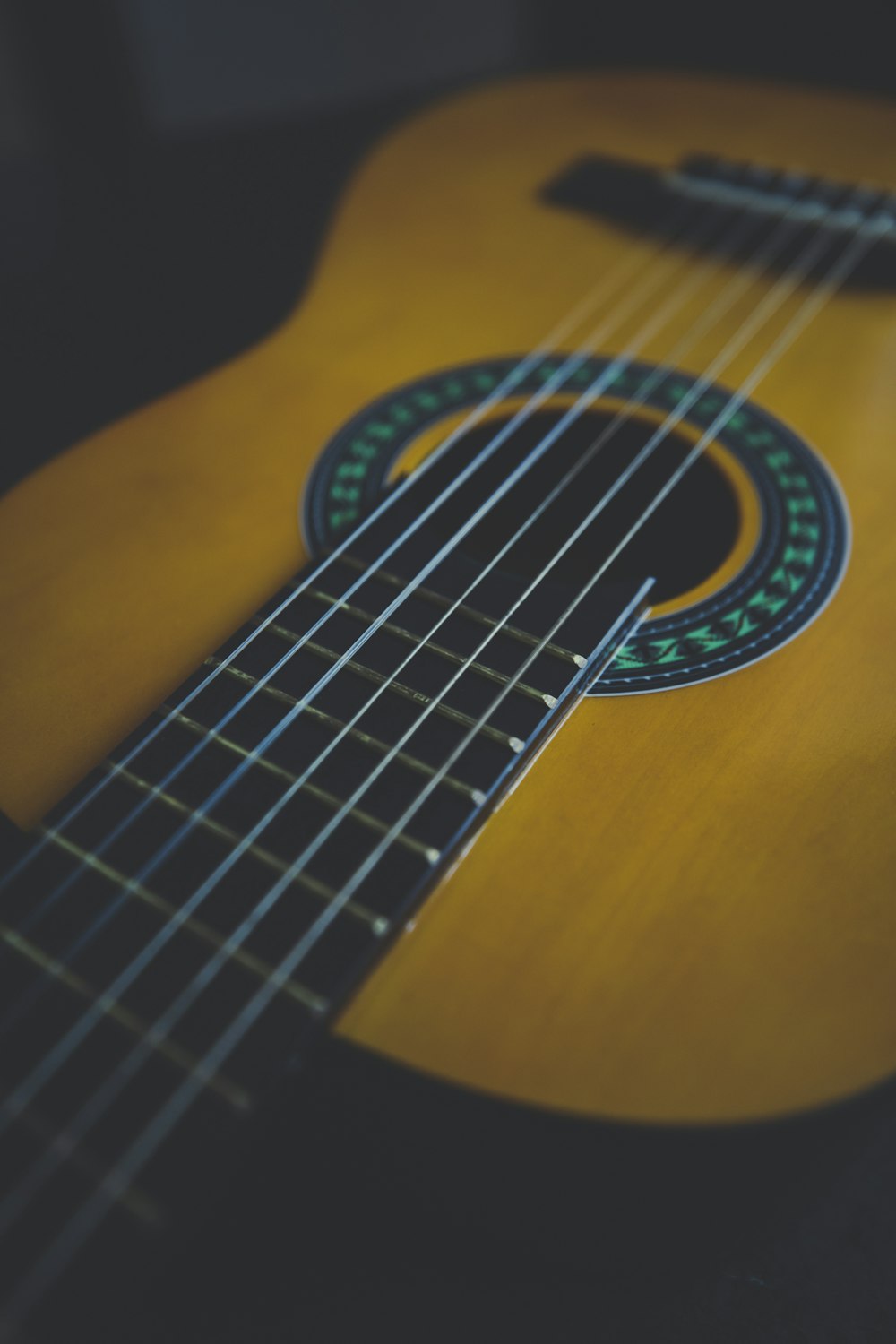 brown acoustic guitar on brown wooden table