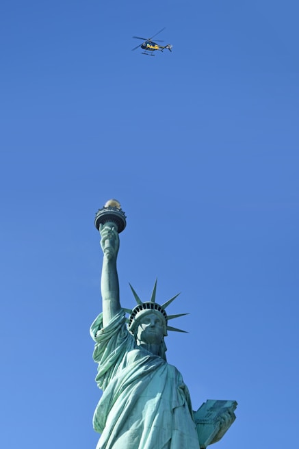 The Statue of Liberty standing tall against a clear blue New York sky