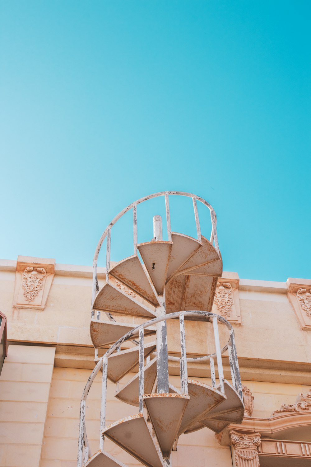 white metal ladder on brown concrete building