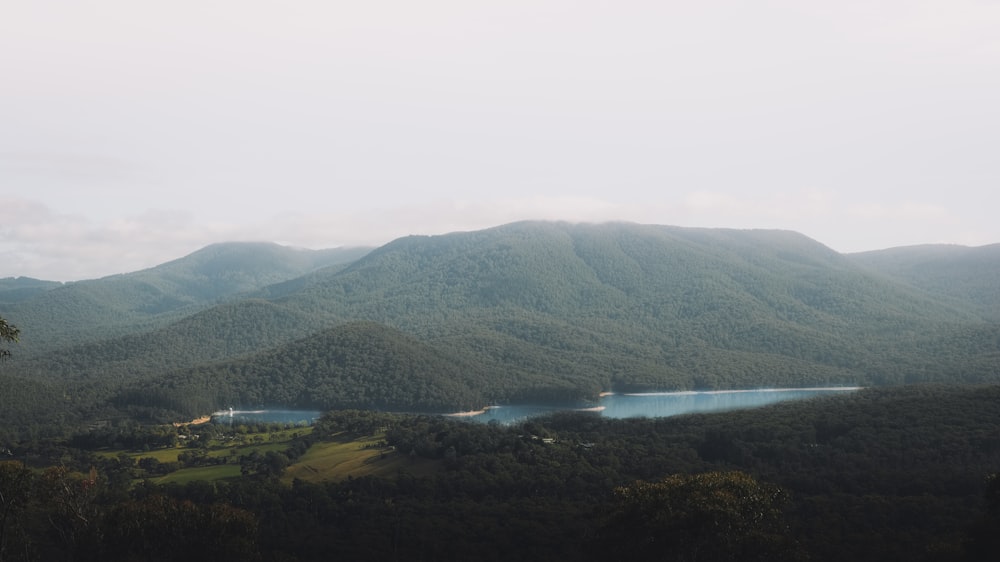 green mountains near body of water during daytime