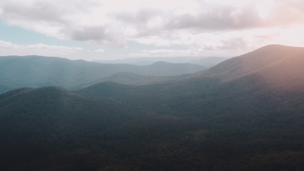 green mountains under white clouds during daytime