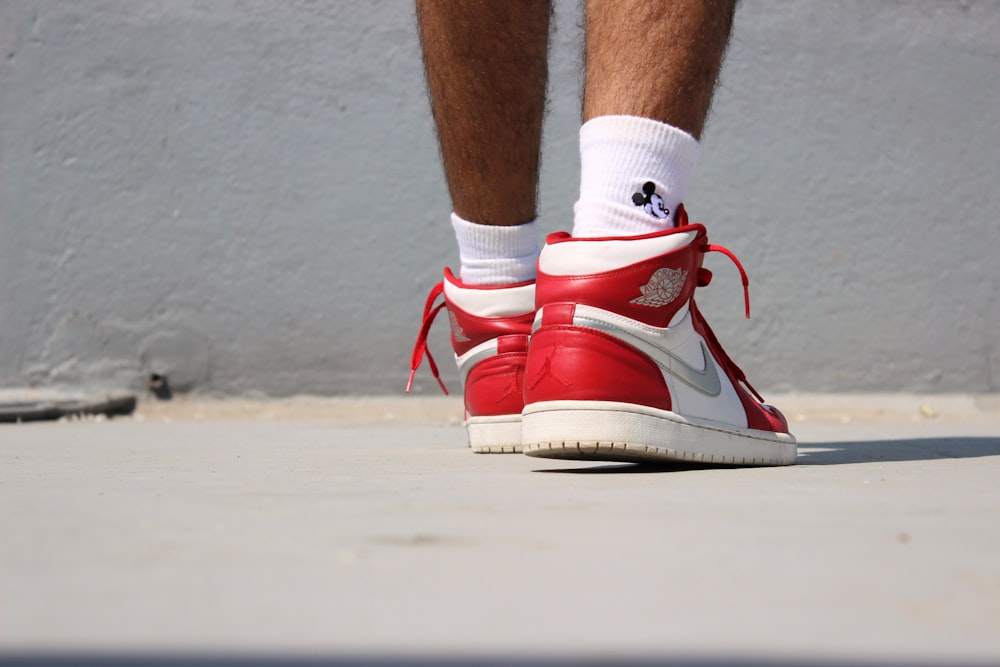 person in red and white nike sneakers