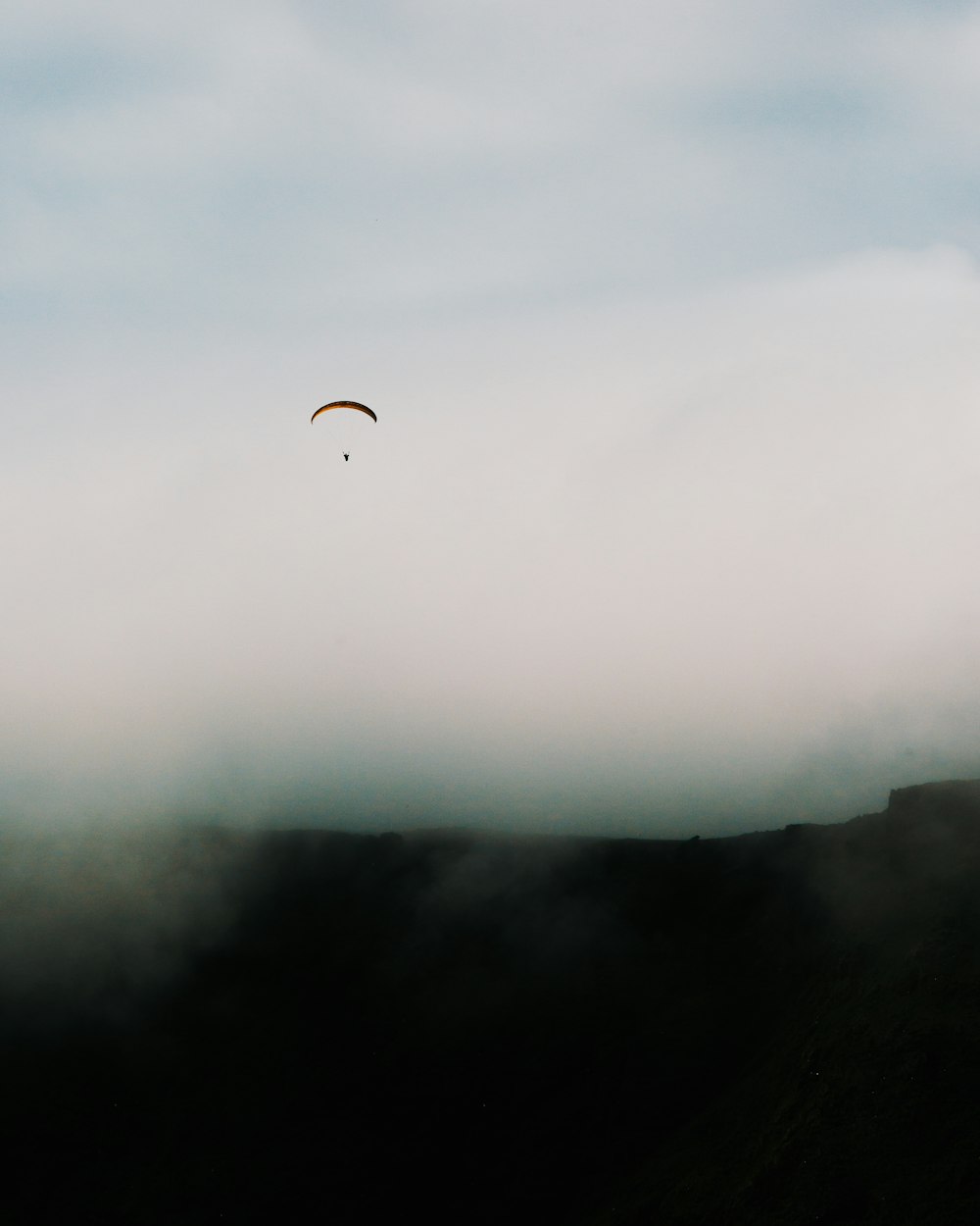 person in black jacket and blue jeans on mid air during foggy weather