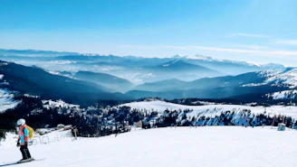 A panoramic shot of a winter ski outfit laid out on snow, featuring soft blues and whites.