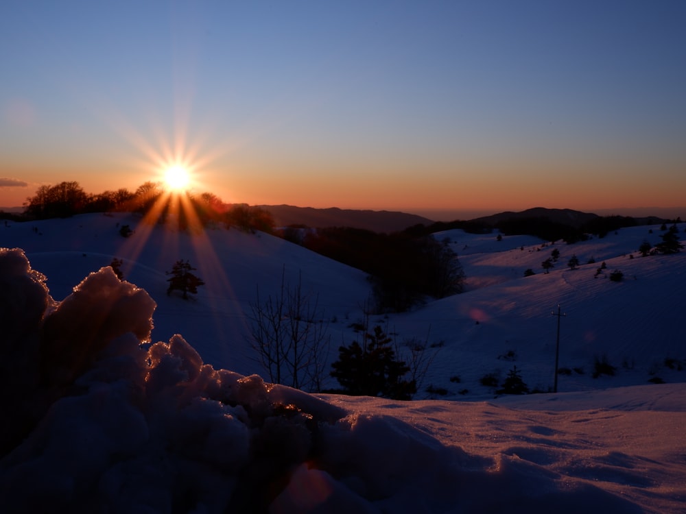 snow covered field during sunrise