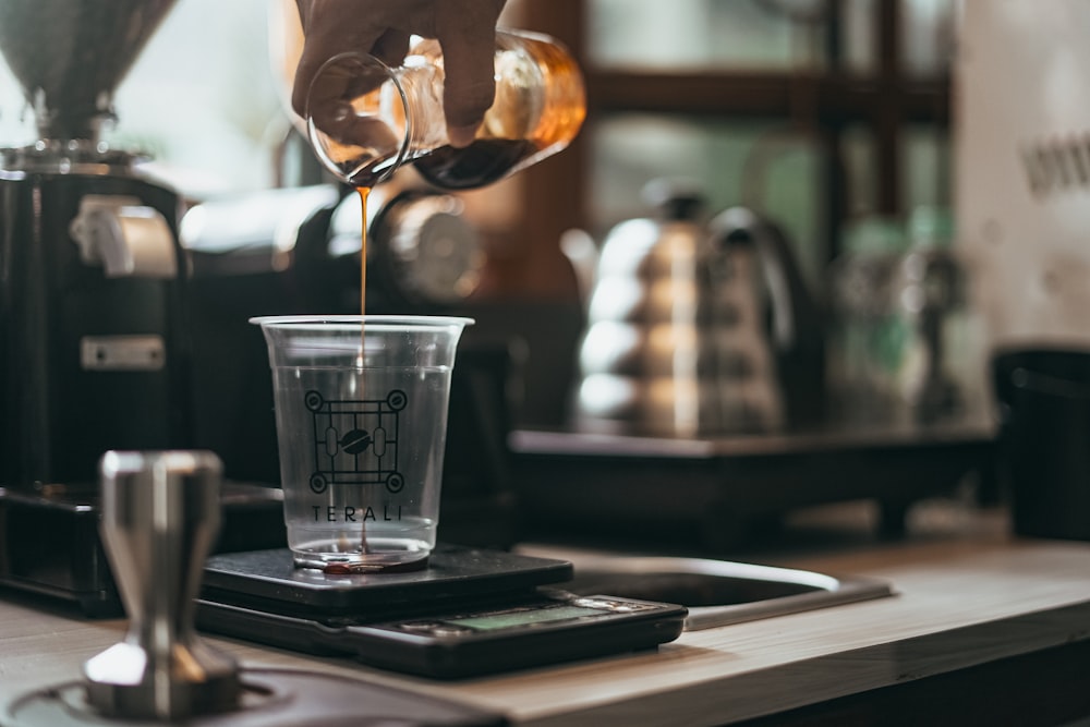 clear plastic cup with brown liquid