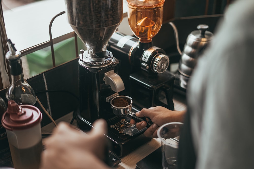 persona che versa il caffè su una tazza di vetro trasparente