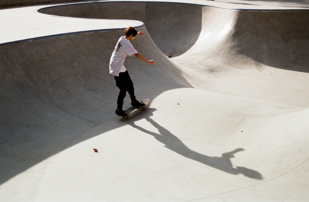 man in white long sleeve shirt and black pants walking on white concrete floor during daytime