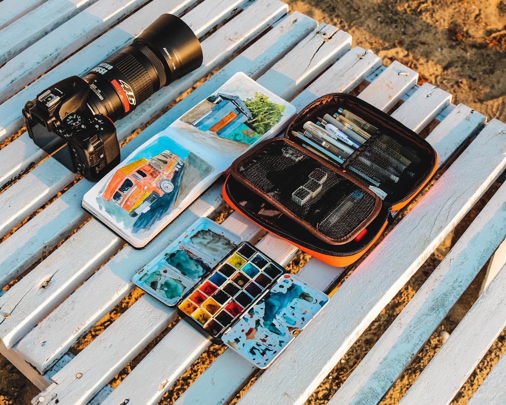 black and orange camera on white wooden table