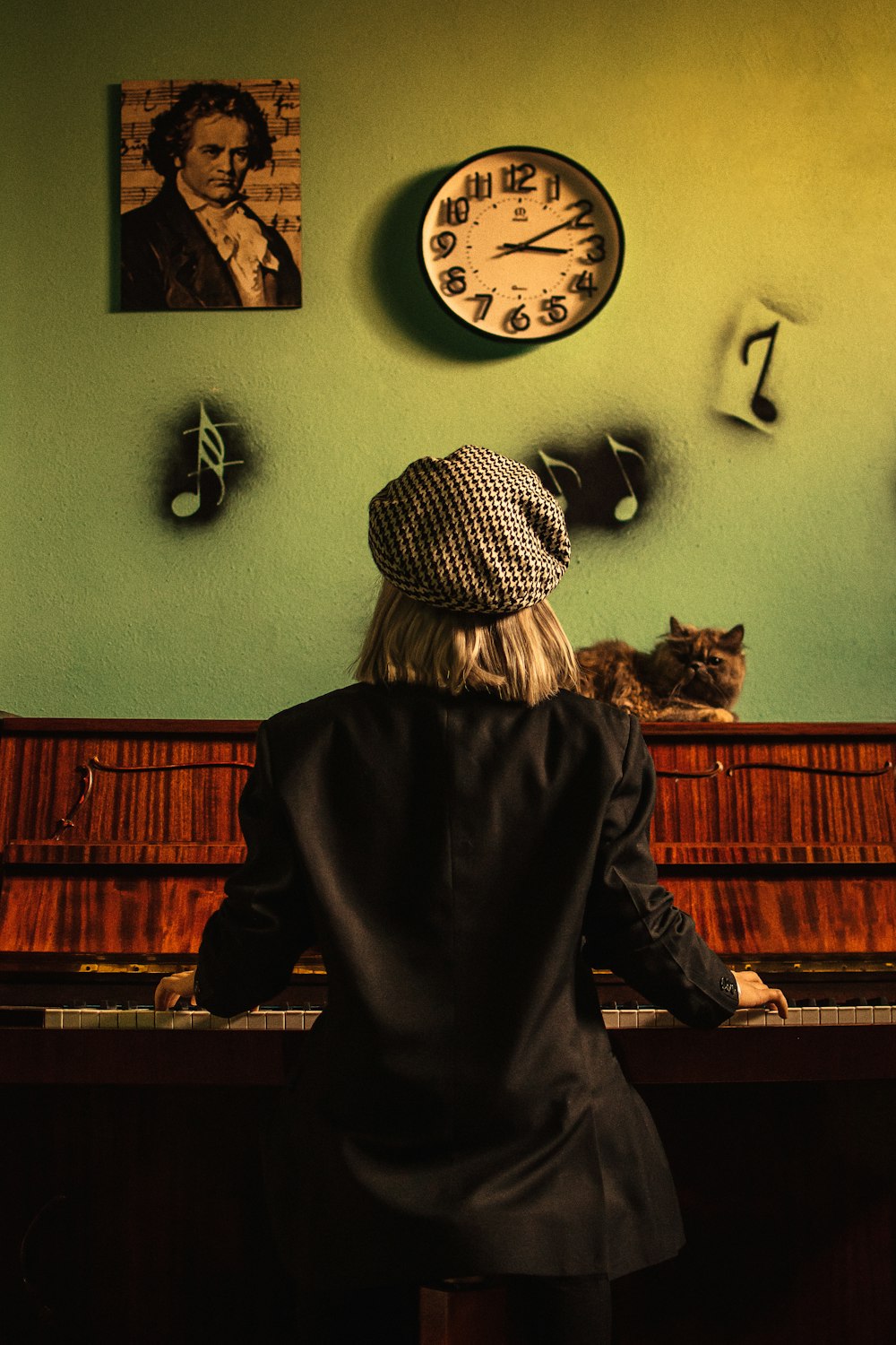 woman in black jacket and white and black striped knit cap standing near brown wooden piano