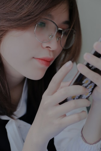 A person using glasses while interacting with a smartphone.