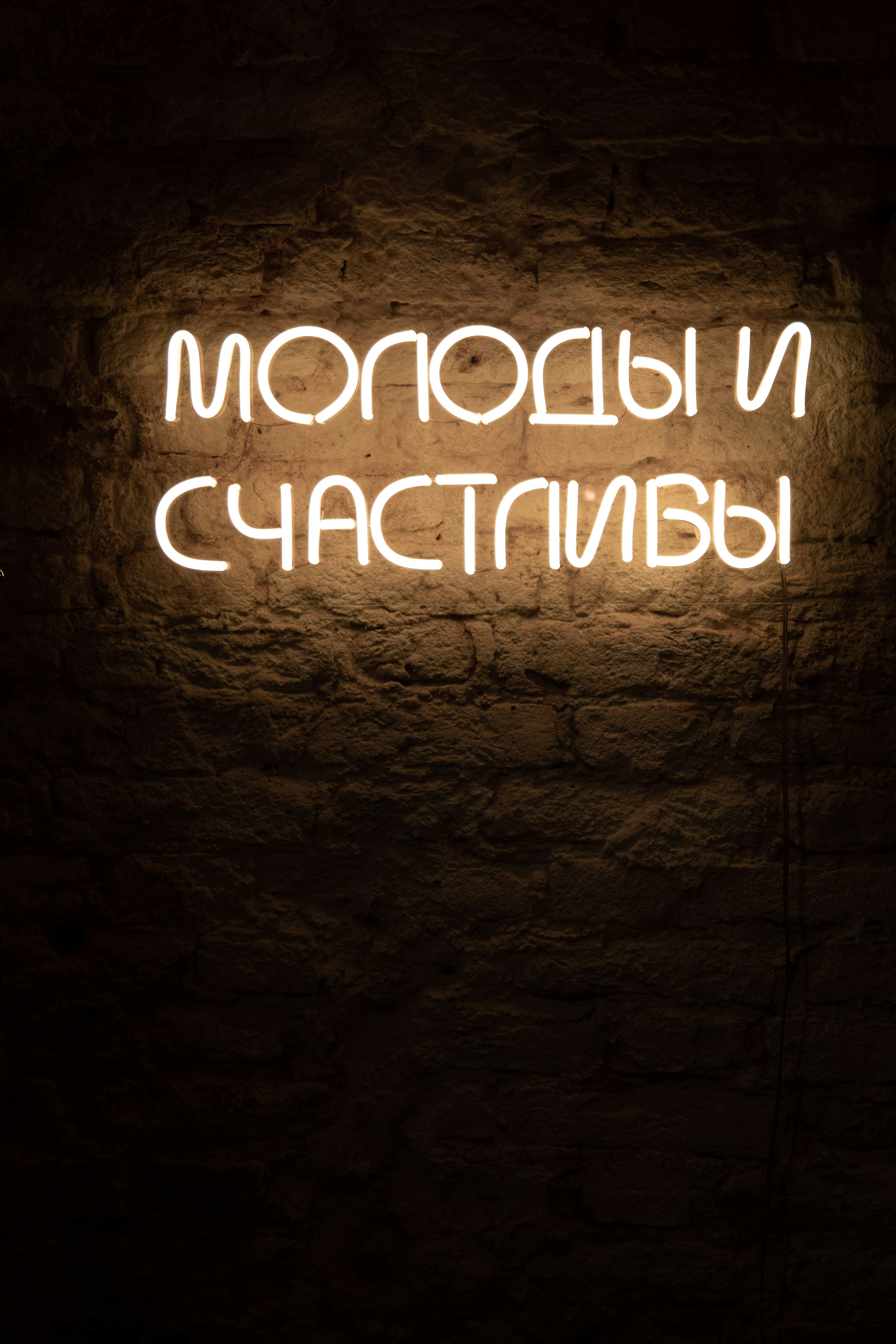 a brick wall with a neon sign on it