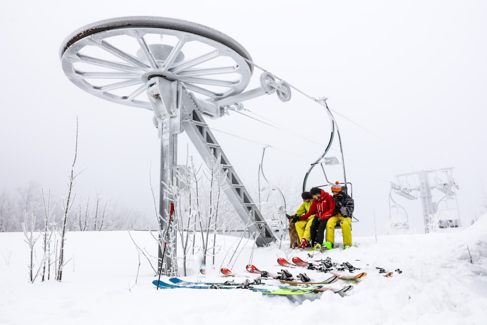 people riding ski lift on snow covered ground during daytime