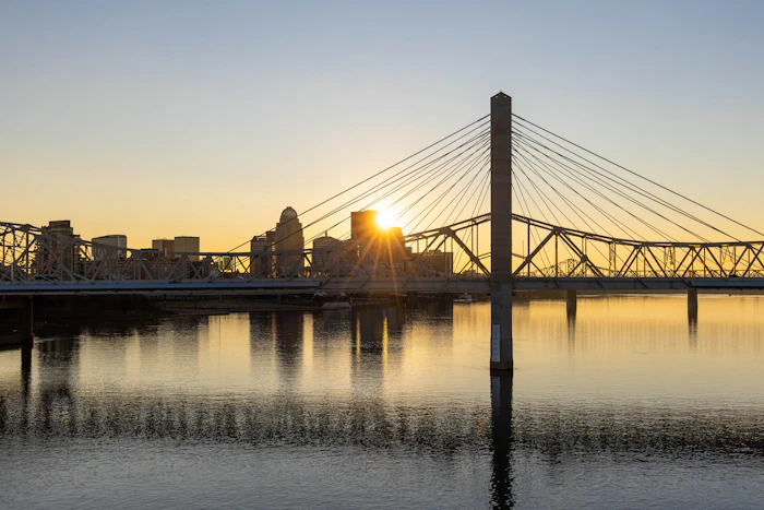 Sunset over downtown Louisville with a bridge crossing the Ohio River