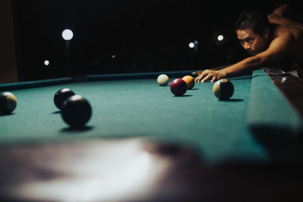 man in black shirt playing billiard