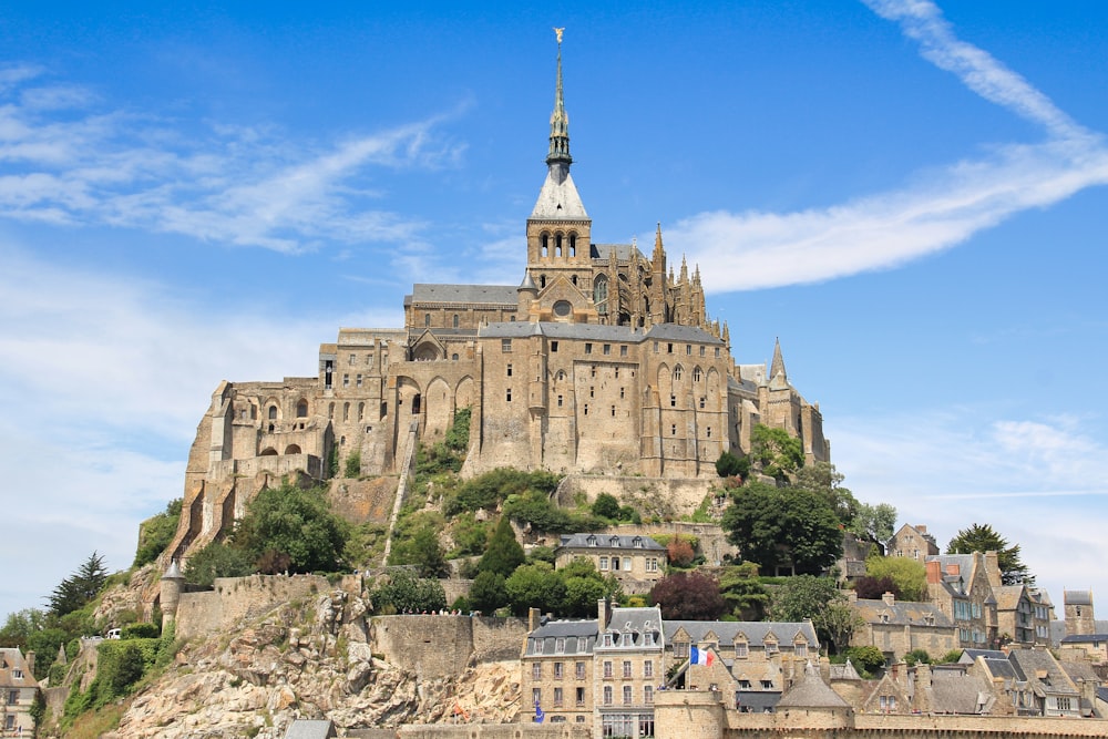 a castle with a steeple on top of a hill