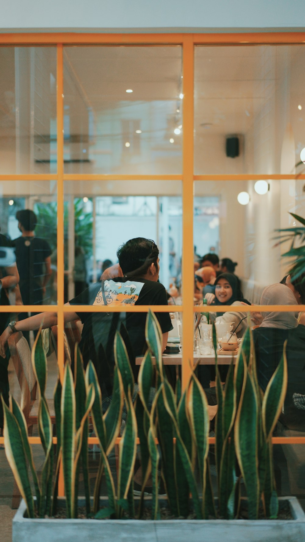 man in black t-shirt standing near glass window