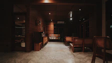 Bright non-AC room featuring warm wooden furniture and soft lighting.