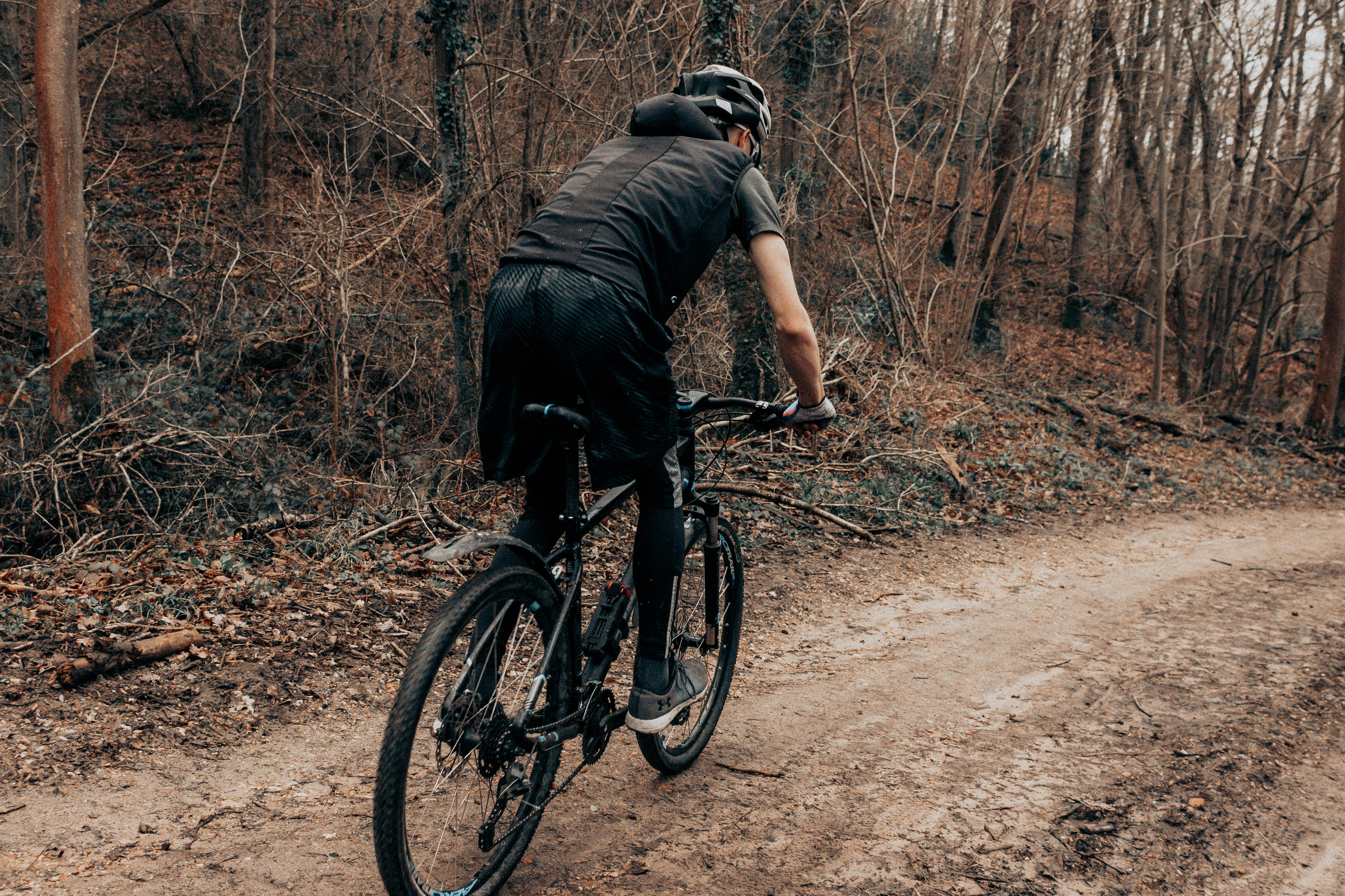 man in black t-shirt riding black mountain bike