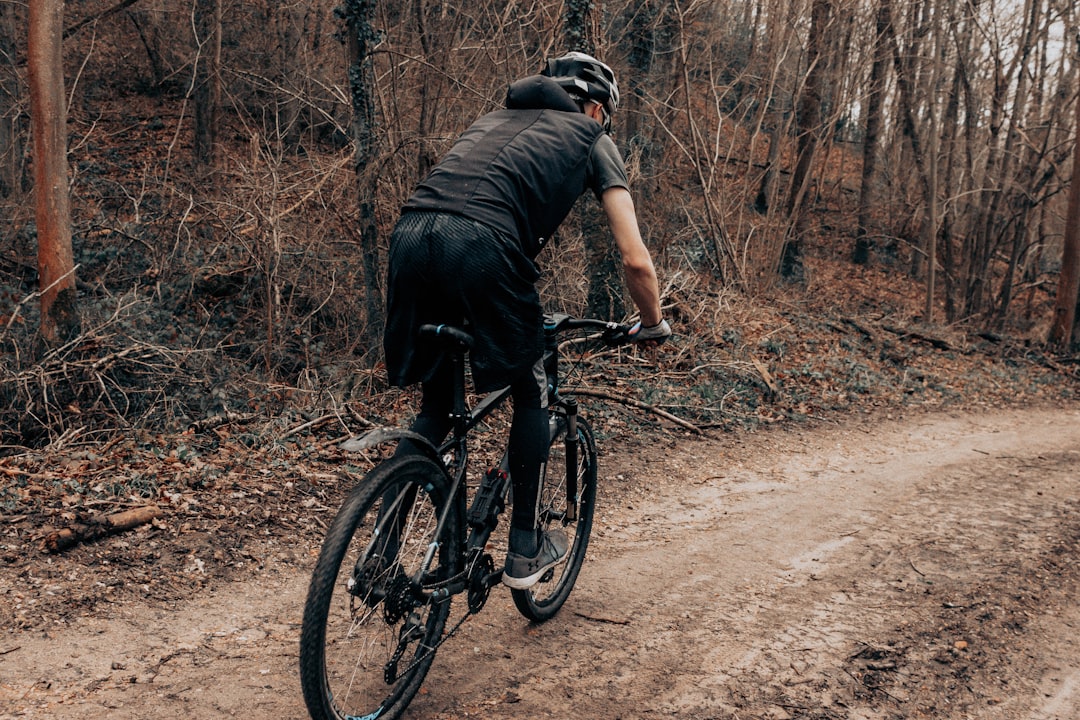 man in black t-shirt riding black mountain bike