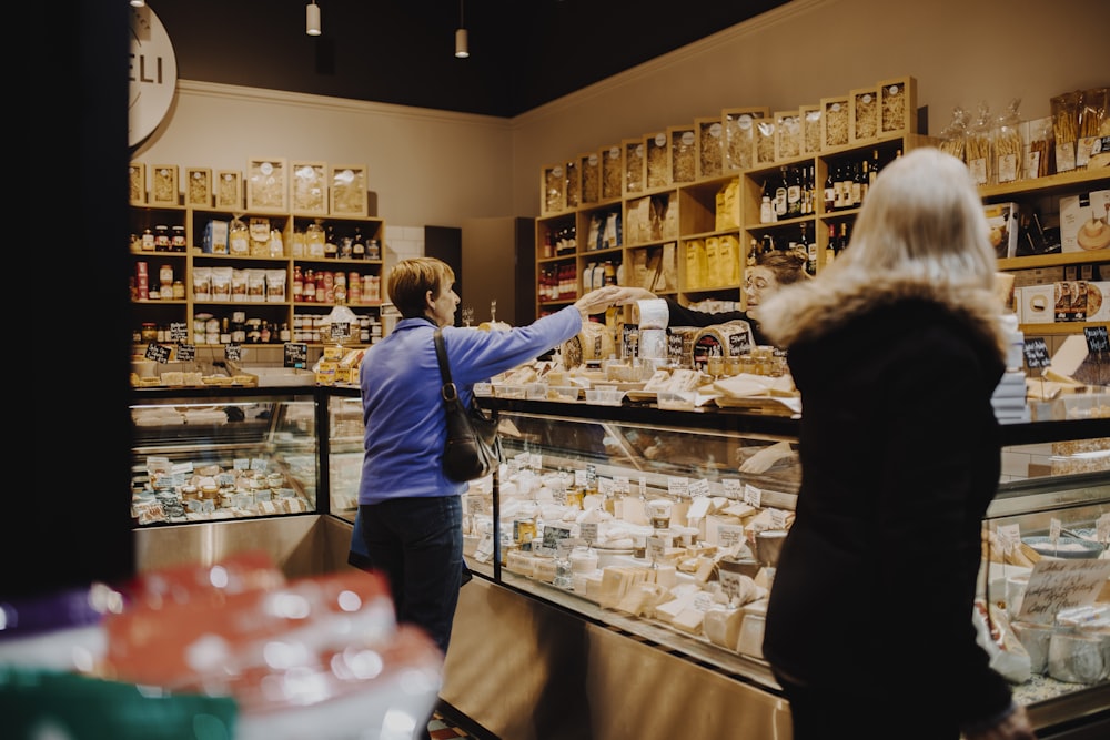 man in blue jacket standing in front of counter