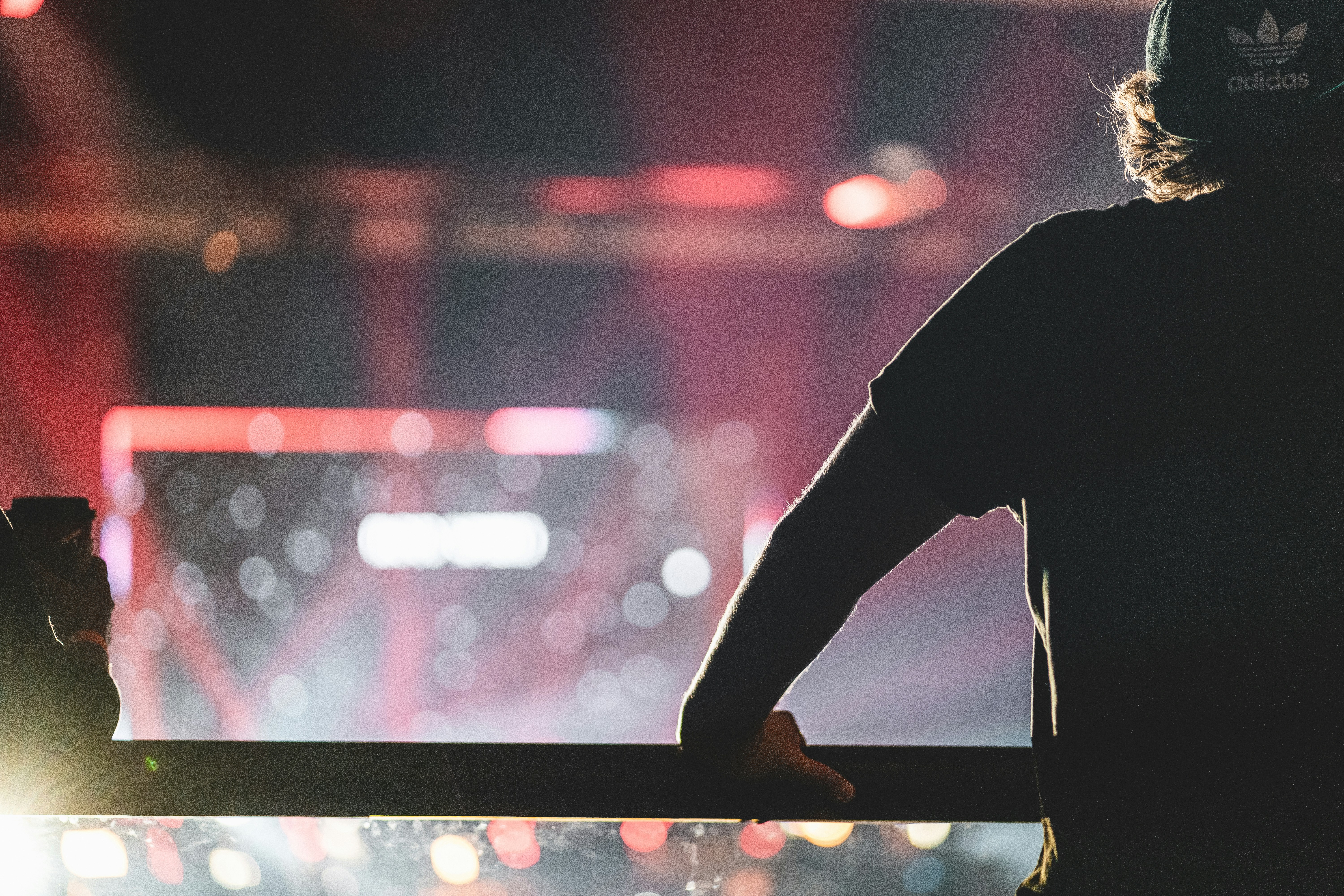 person in black pants standing on black metal bar during night time