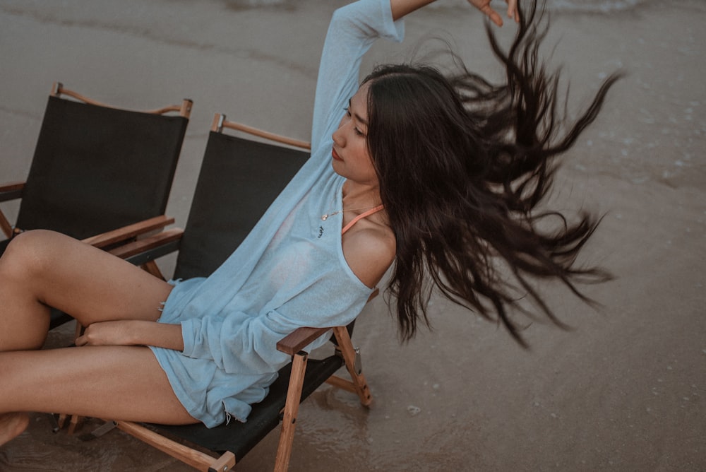 woman in white shirt sitting on brown wooden chair