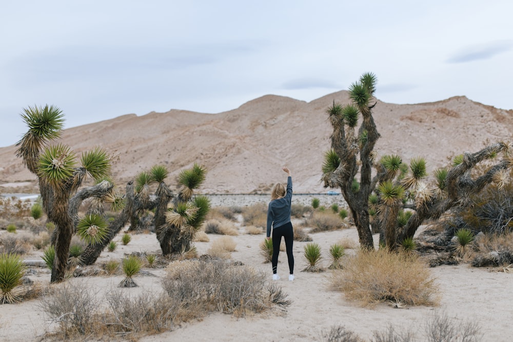 man in blue jacket standing on brown sand during daytime