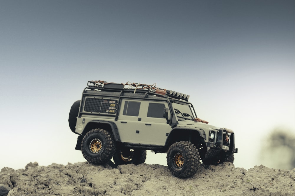 Jeep Wrangler blanc et noir sur sable blanc pendant la journée