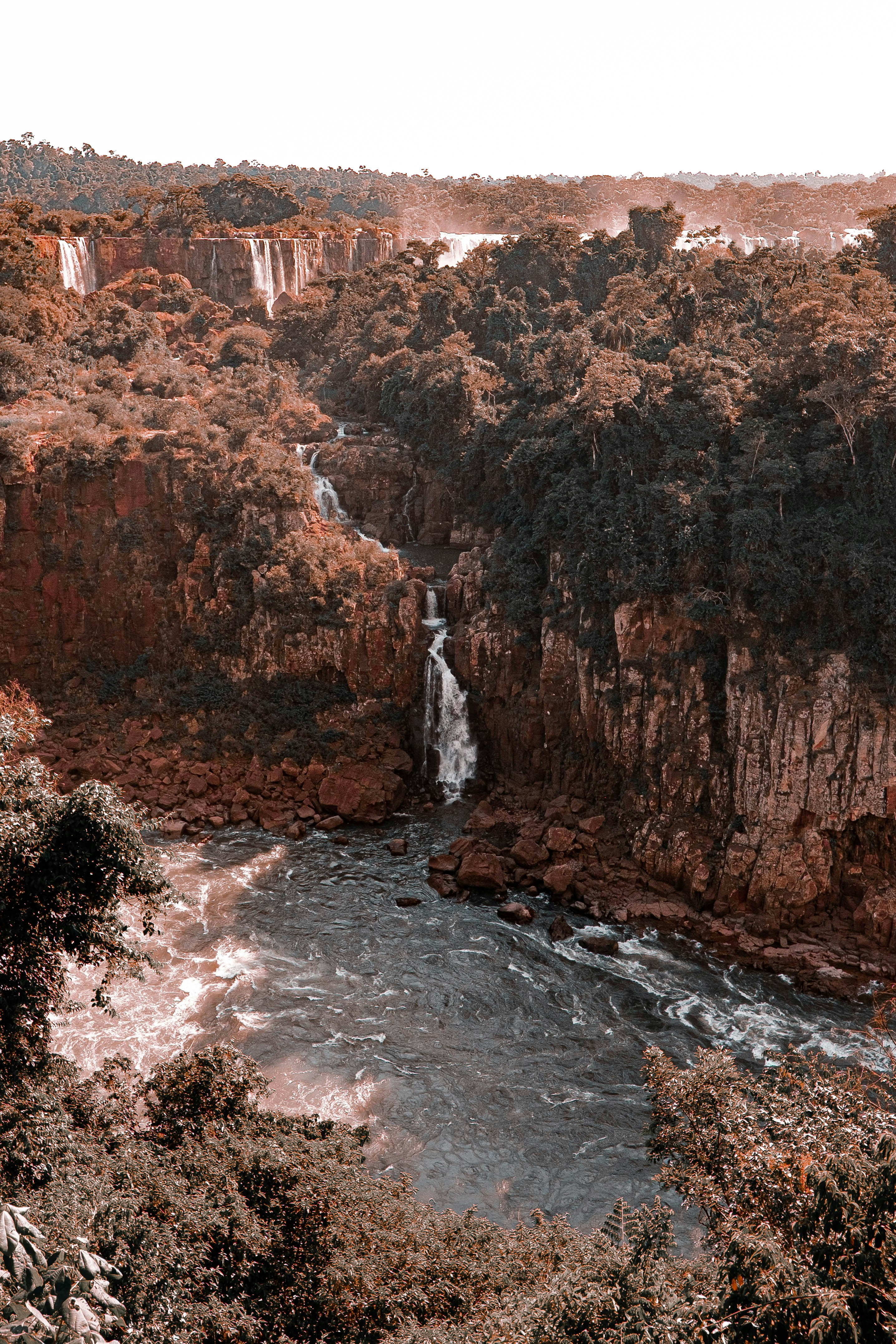 brown and green mountain beside river during daytime