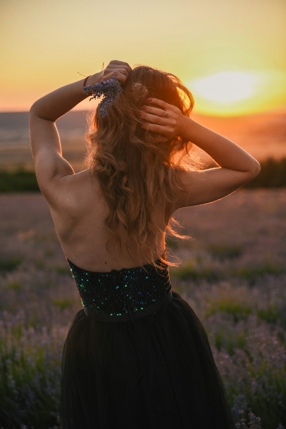 woman in black tube dress holding orange ball