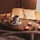 Warm-toned image of a serene reading nook with a ceramic cup and open journal on a wooden table.
