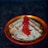 A decorative plate holds several folded crepes with golden brown spots. A generous amount of vibrant red caviar is placed on top of the crepes, adding a touch of elegance to the dish. The plate has a colorful border, enhancing the visual appeal against the dark background.