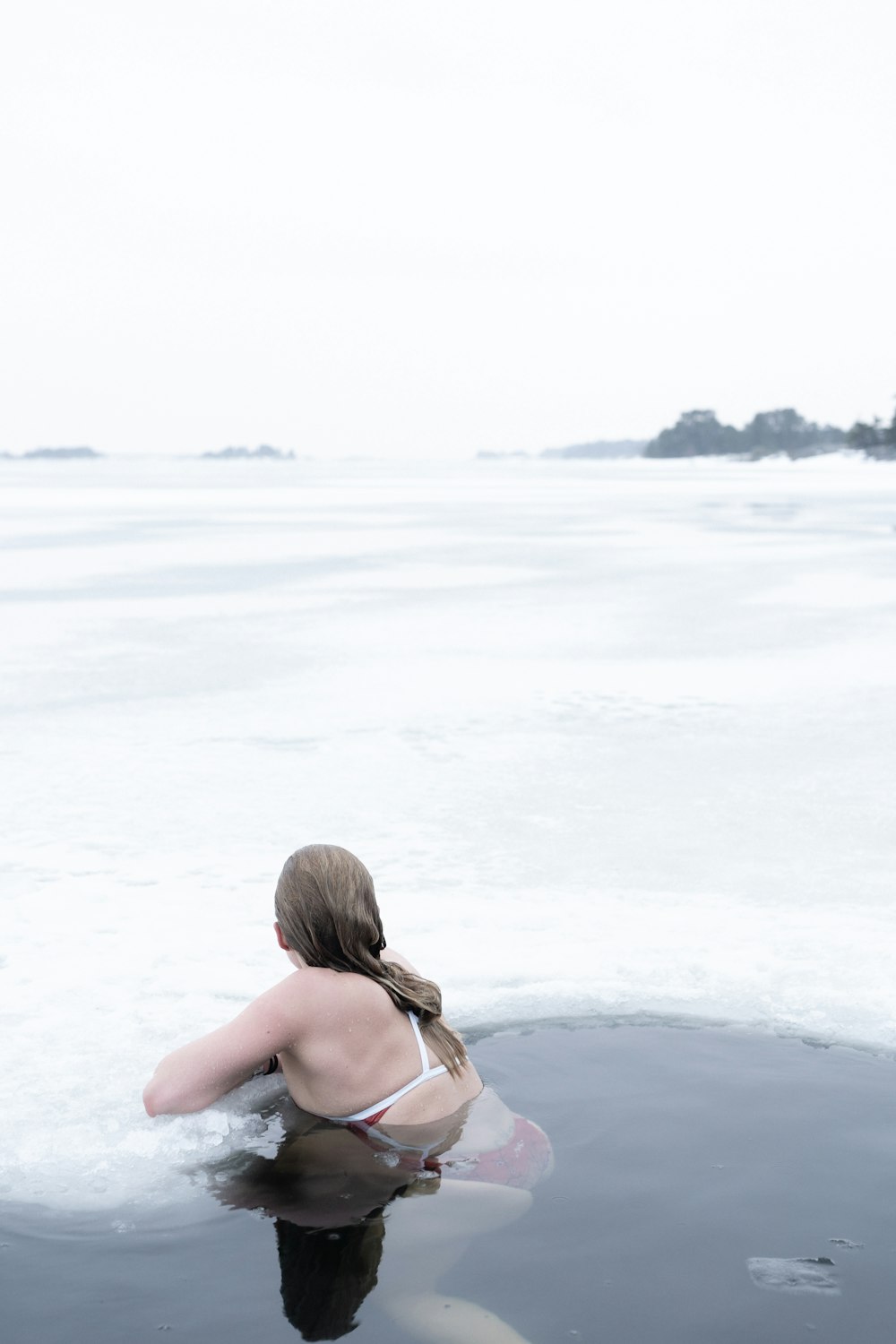 woman in black bikini top standing on white sand during daytime