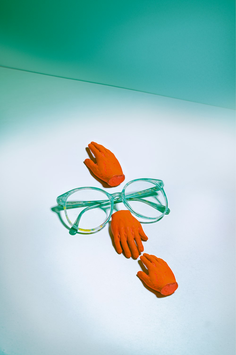 green framed eyeglasses beside orange rose