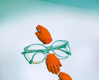 green framed eyeglasses beside orange rose