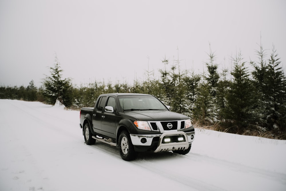 日中の雪に覆われた地面の黒いフォードSUV