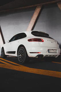A polished white Porsche gleaming under soft, moody lighting with a minimalist background