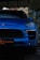 A blue luxury sports SUV parked indoors, with a polished exterior and prominent brand emblem on the front grille.