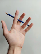 person holding blue pencil on left hand
