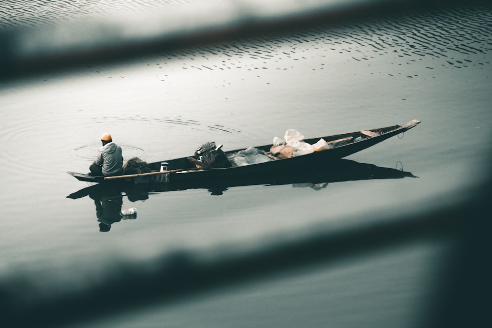 man in white shirt and black pants on boat during daytime