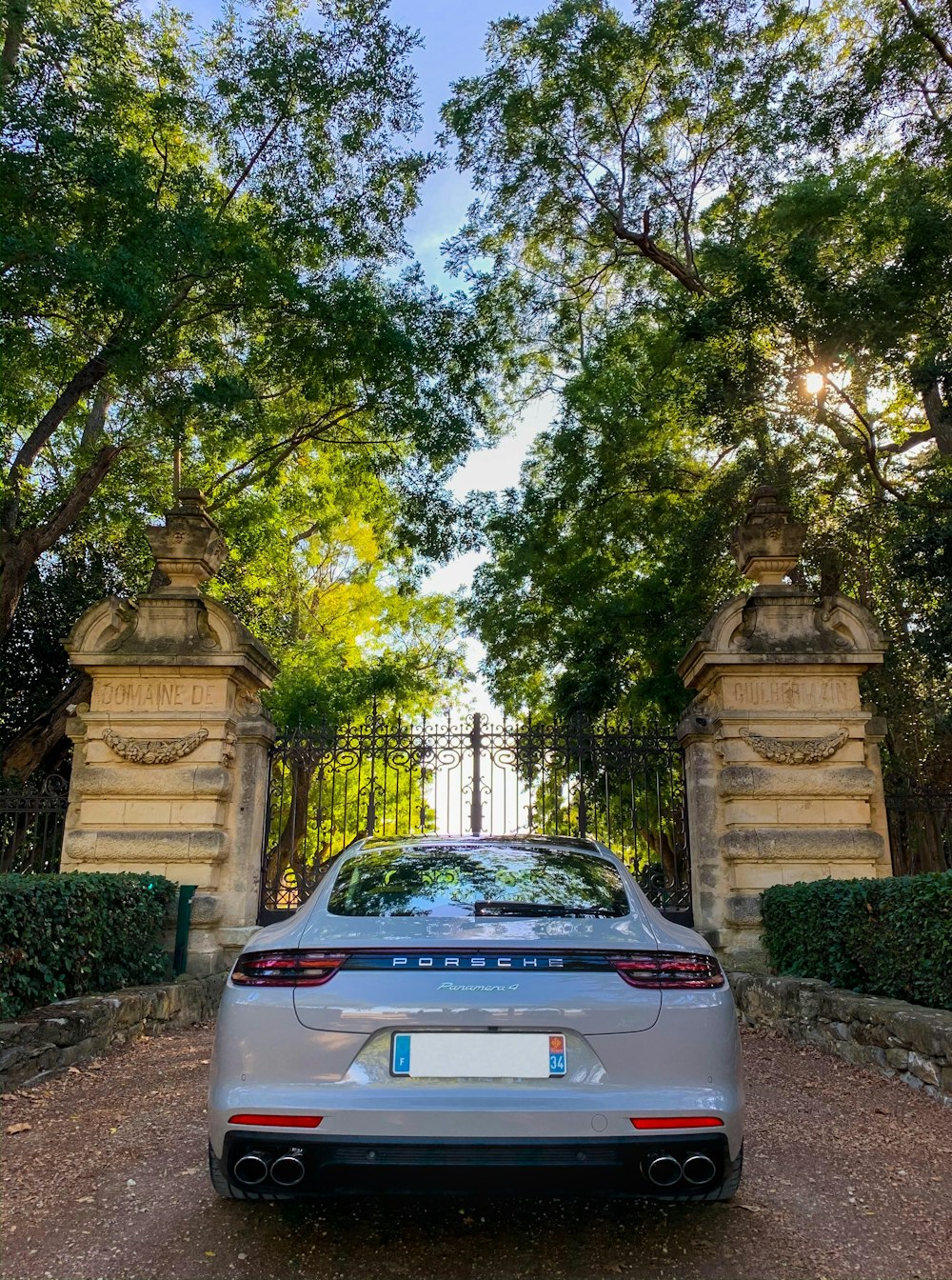 white car parked near green trees during daytime