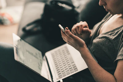 man in black shirt writing on white paper