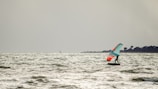 A group of friends enjoying a wing foiling session at sunset.