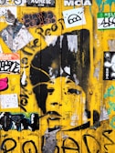 A vibrant acid yellow dripping paint effect layered over a gritty black wall, with sticker overlays adding texture.