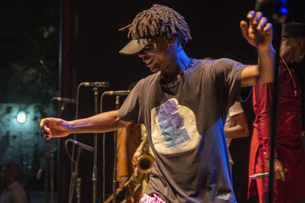 man in grey t-shirt playing saxophone