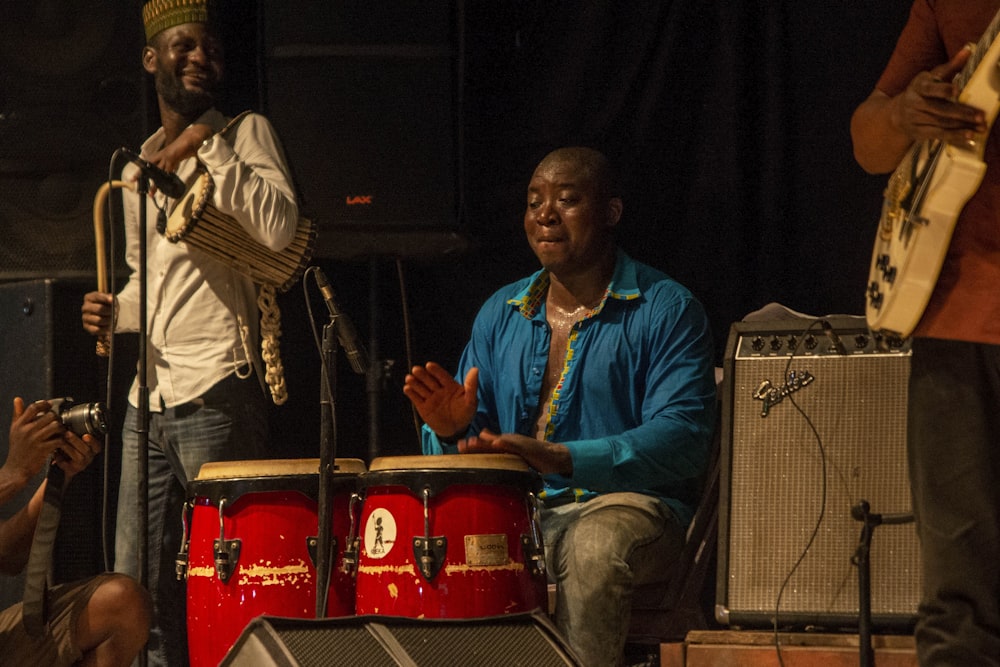 man in white dress shirt playing drum set