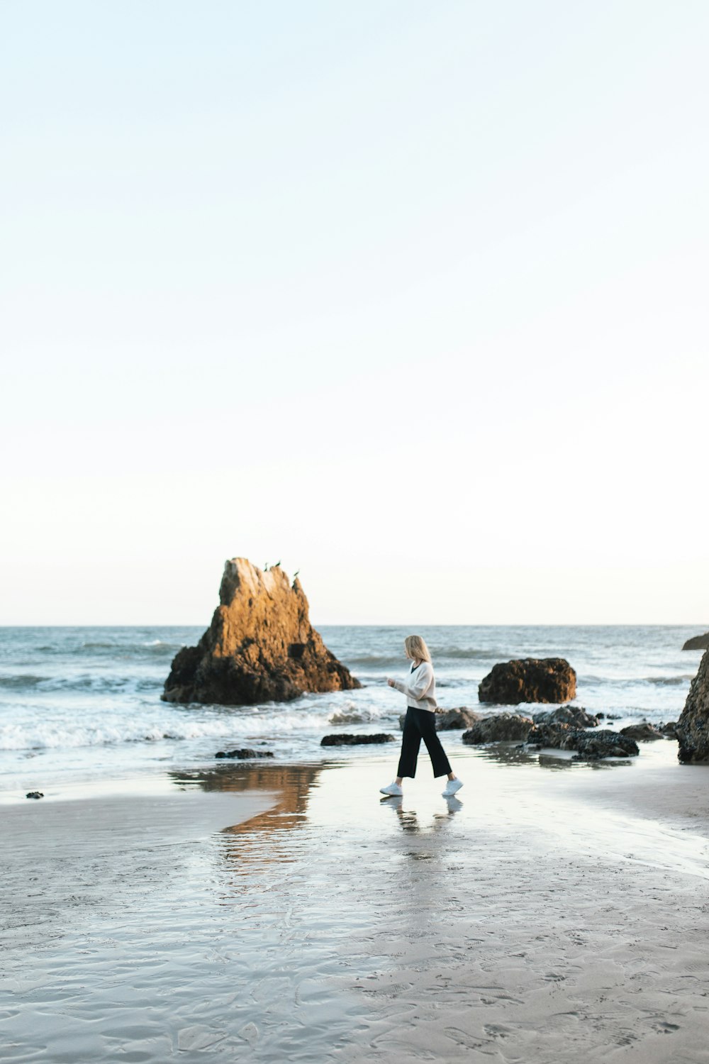 2 women walking on beach during daytime