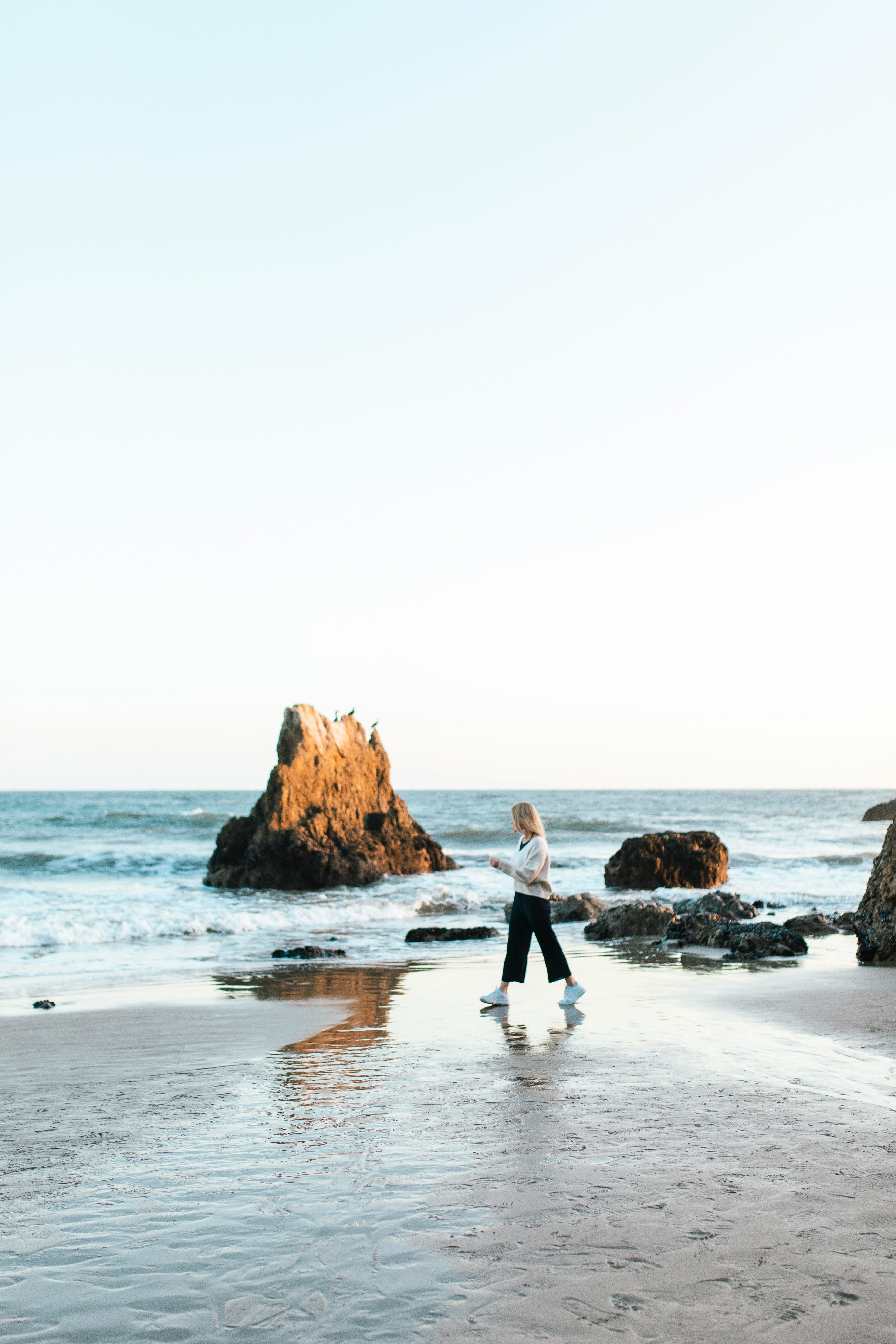 2 women walking on beach during daytime