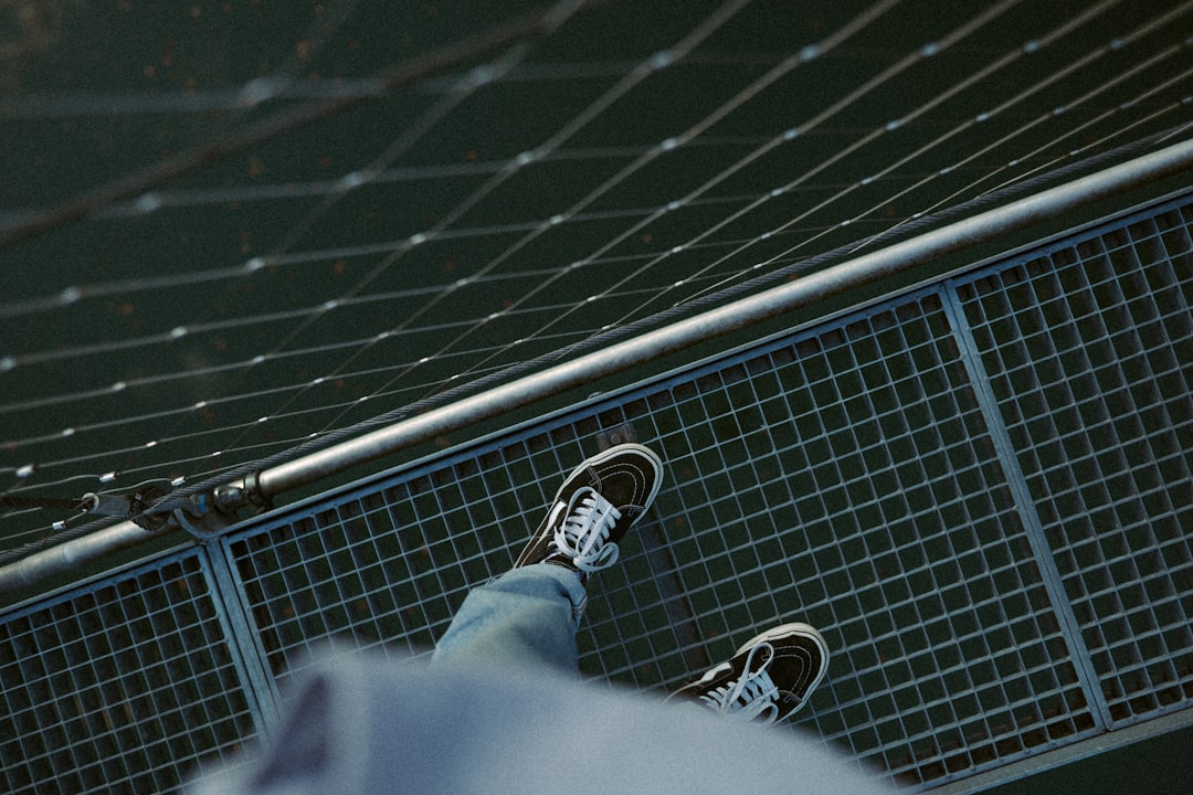 person in black pants and black and white sneakers